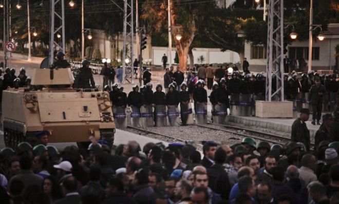 Egyptian riot police stand guard as protesters demonstrate in front of the presidential palace in Cairo on Dec. 7. 