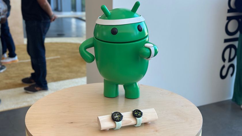 An Android statue wearing a headband and a dummy Pixel Watch 3, standing behind a display of Pixel Watch 3s. 