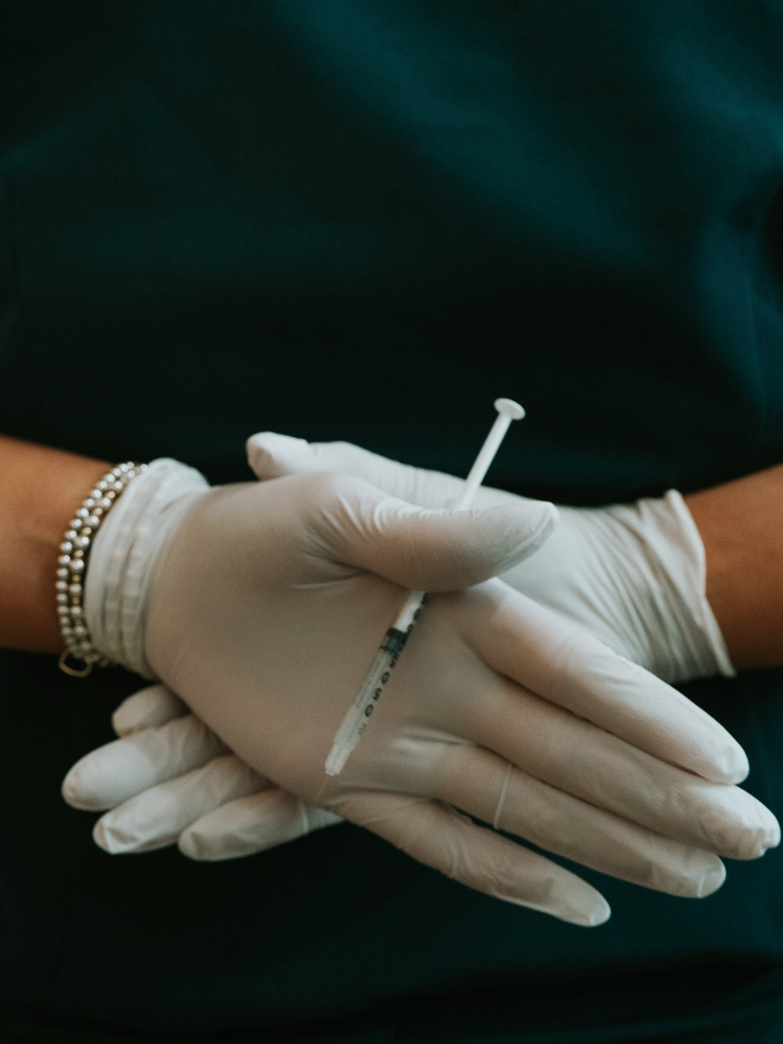 Gloved hands holding a treatment needle