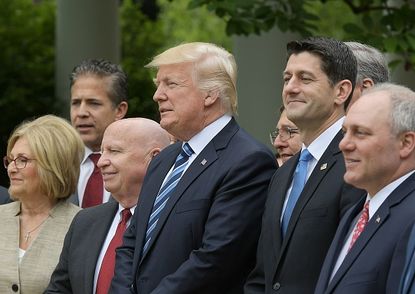 Trump stands with Republican members of the House after the passage of the GOP health-care bill.