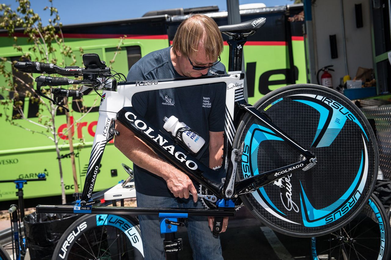 A Team Novo Nordisk mechanic adjust the chainrings for a rider