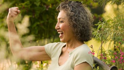 Woman flexing her toned arms outside