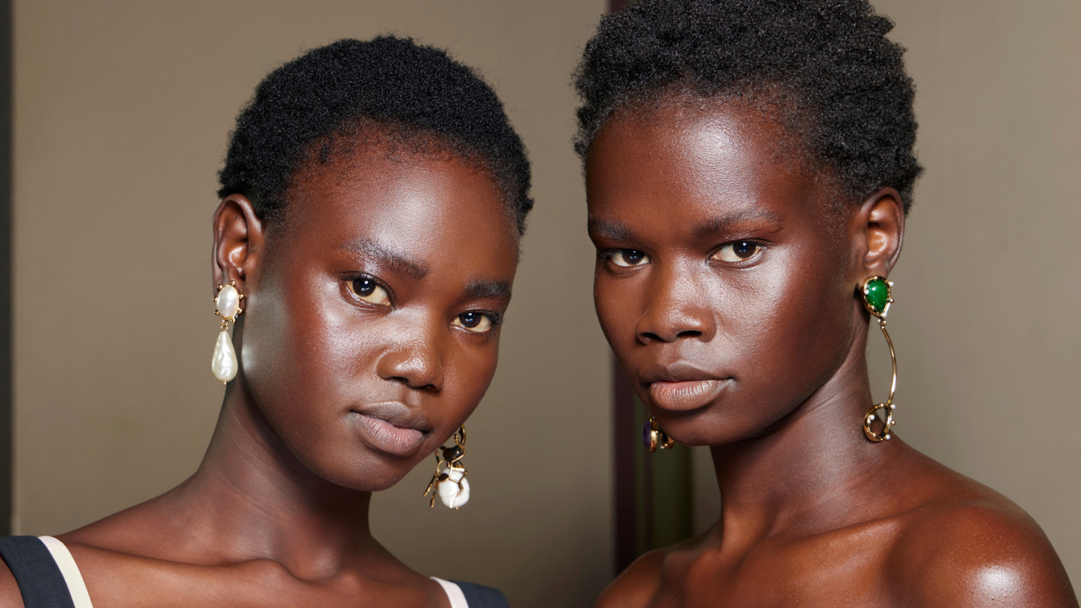 two black woman with large earrings and glowing skin
