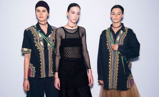 Models wear black embroidered shirts and black dress with fishnet details