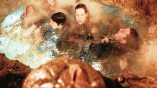 Sigourney Weaver and crew huddled in a pool
