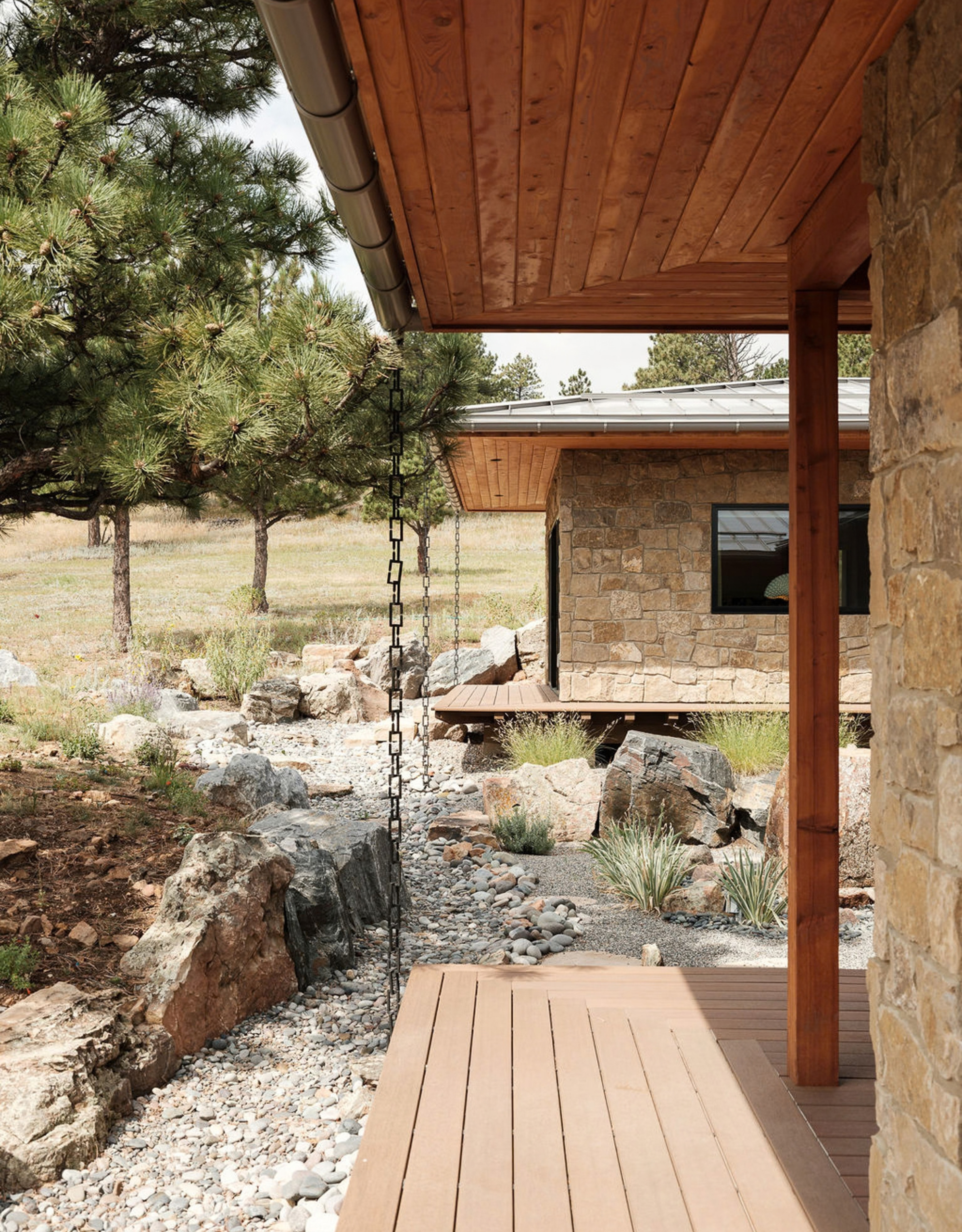 A home with a rock facade and an engawa with rain chains