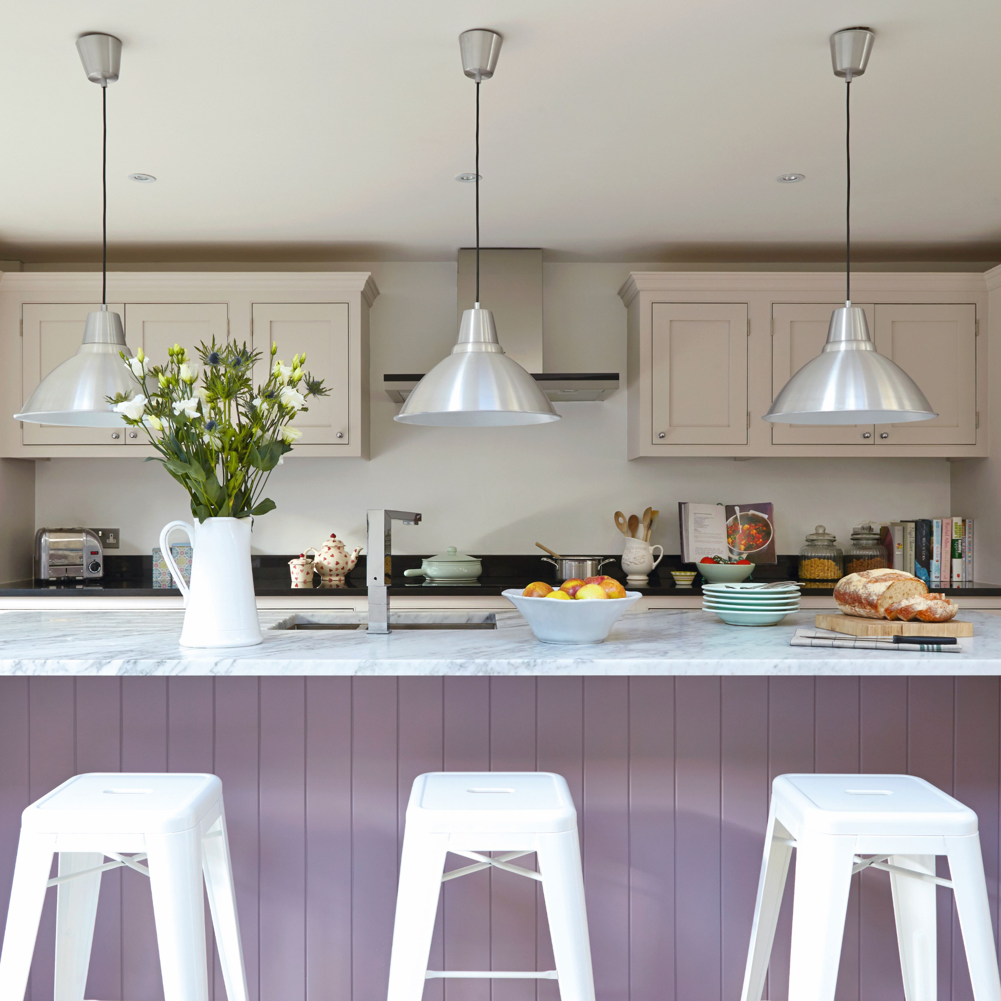 Modern hwite kitchen, large lilac breakfast bar with high bar stools, low hanging pendant lights