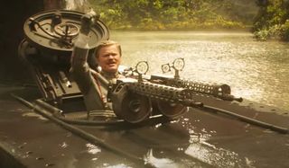 Jesse Plemons looks cheerful behind his machine gun in Jungle Cruise.
