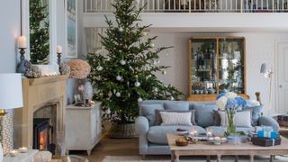Larger living room with taller Christmas tree in the corner to highlight the need to take placement inot consideration when buying a real Christmas tree online