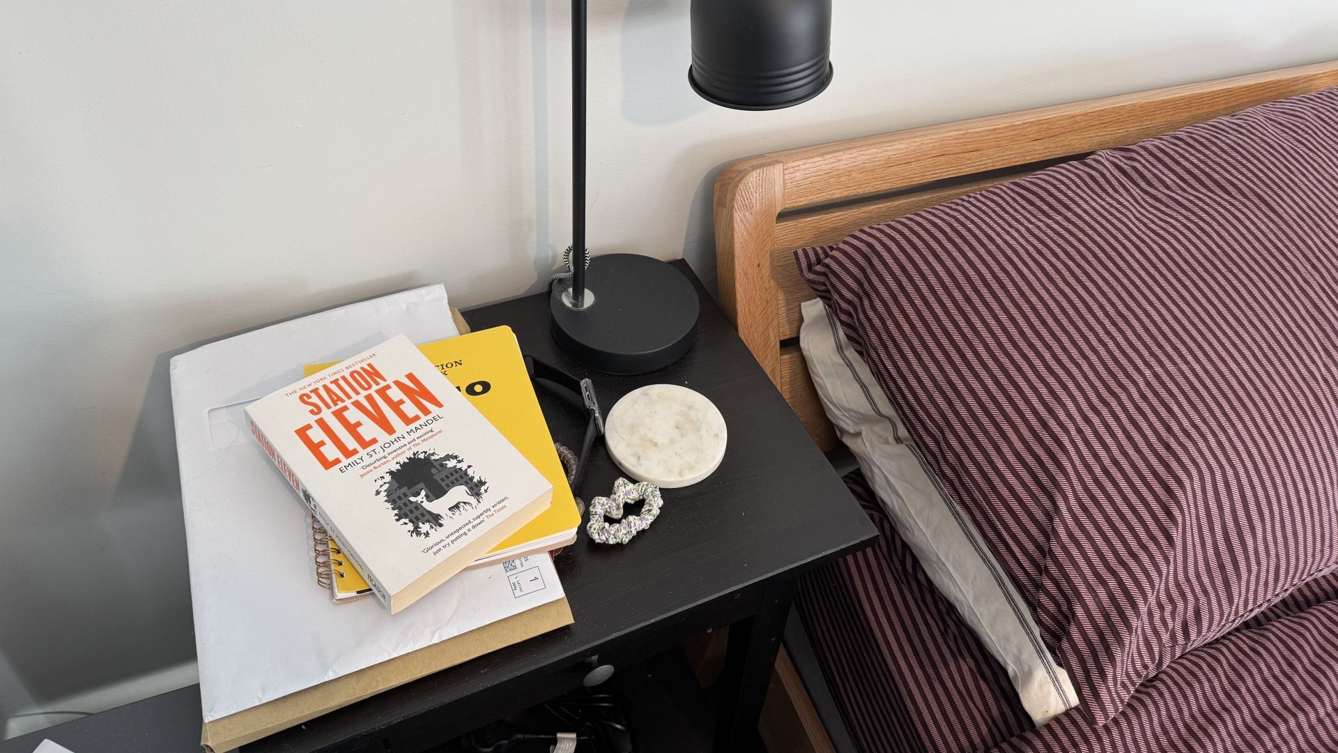 A cluttered side table in a bedroom