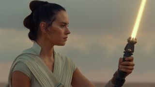 Rey holding lightsaber in Force Awakens