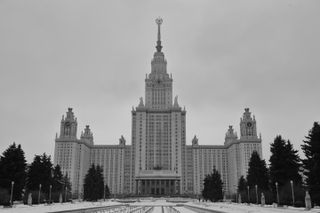 Black and white photo showing Moscow State University with trees to the side.