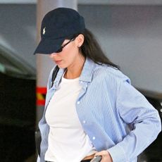 Kendall Jenner wearing a striped button-down, white T-shirt, and jeans
