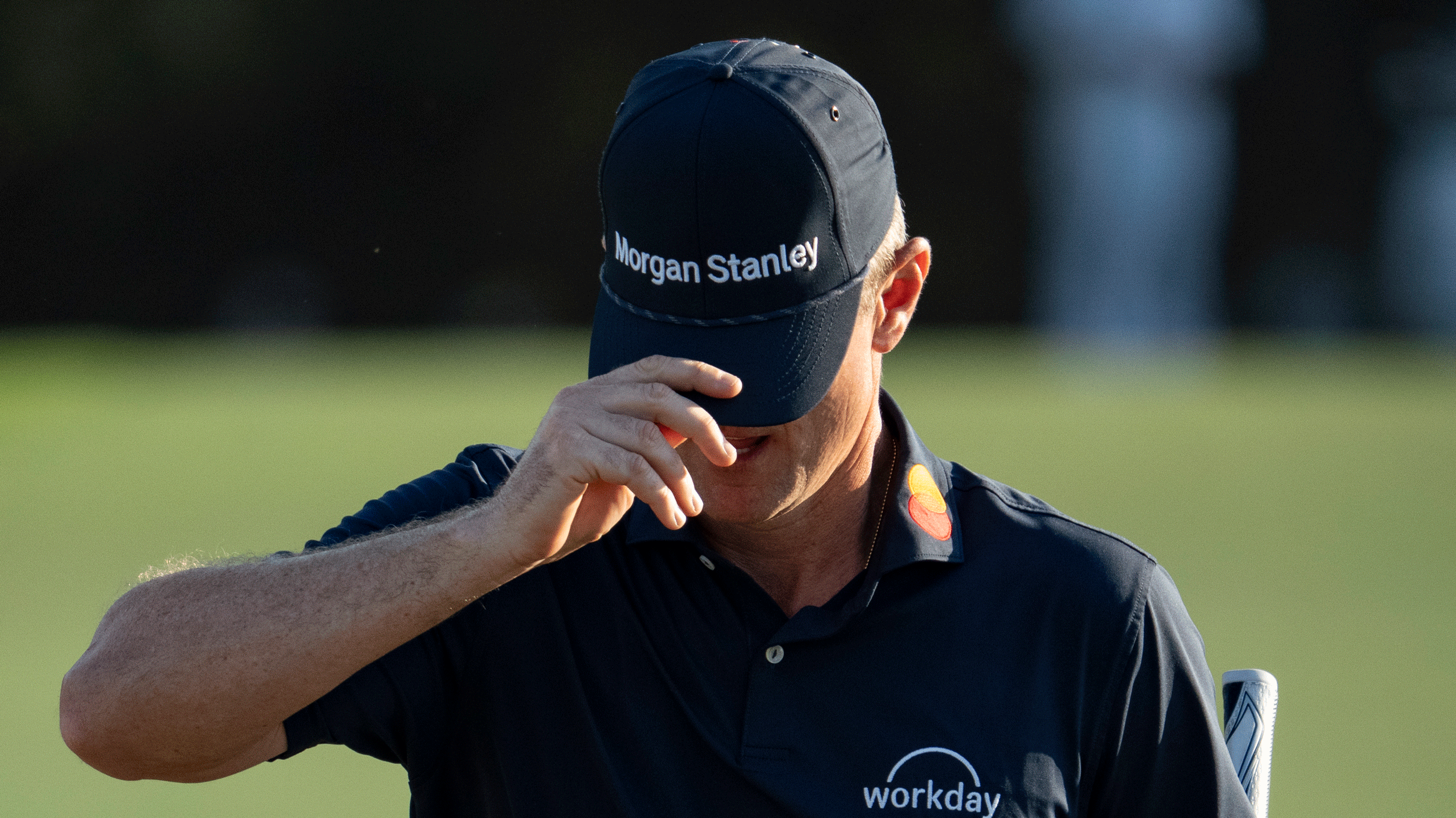 Justin Rose hides his face with his cap after coming off the 18th green at Augusta National following round four of the 2026 Masters