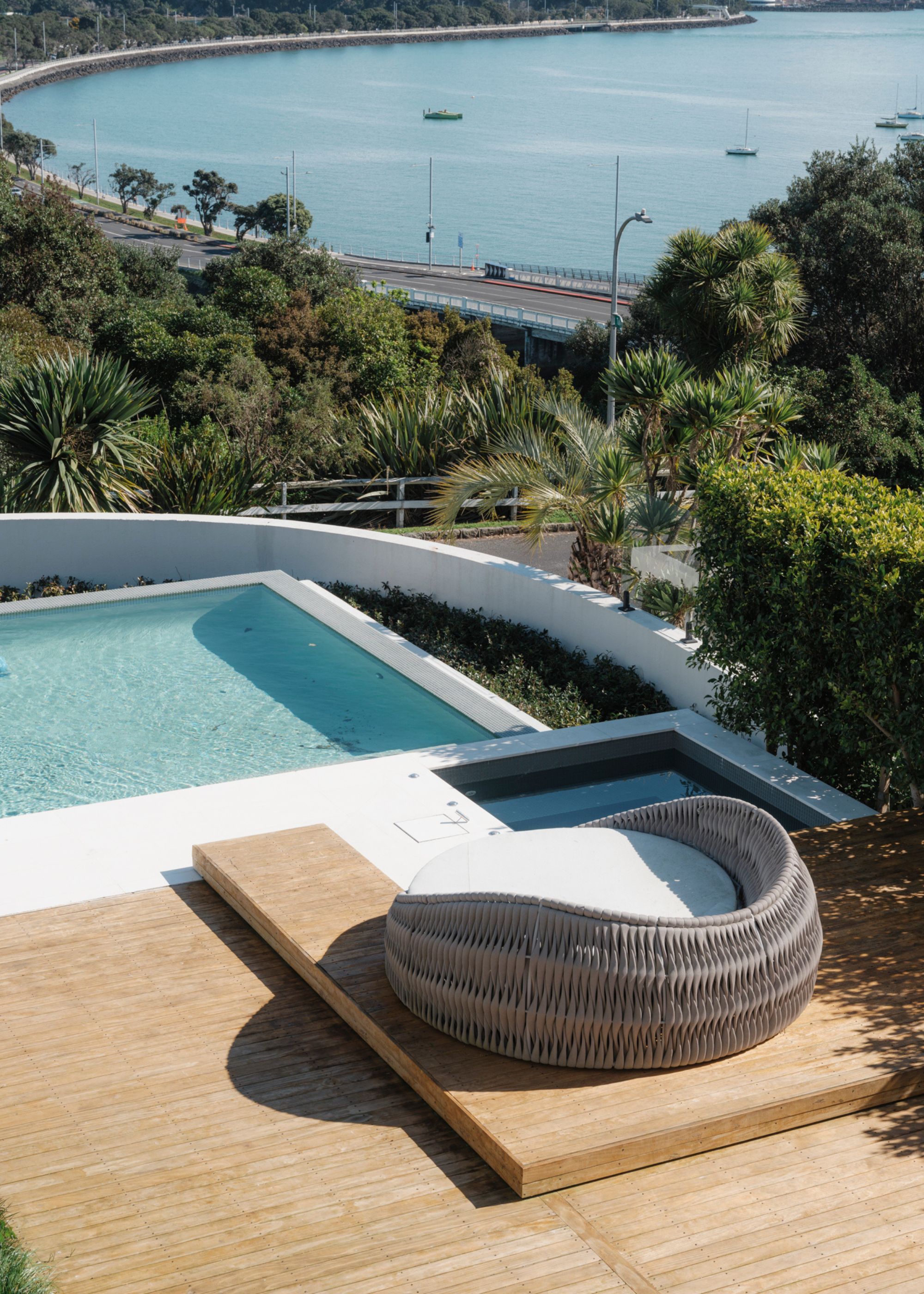 A large patio seating area next to a large pool in the backyard of a home