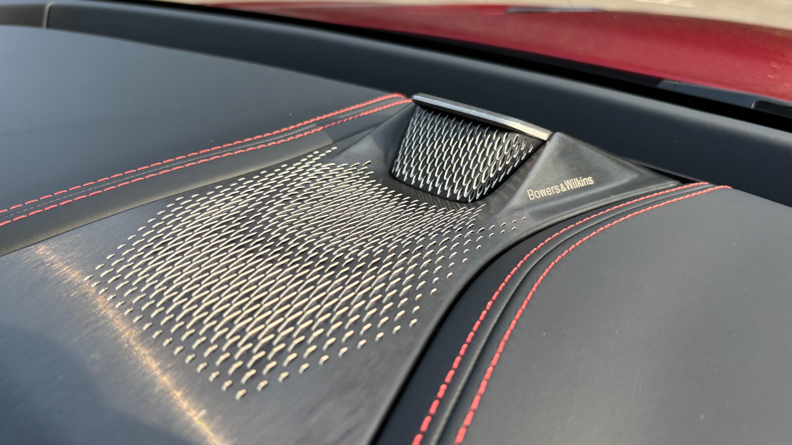 Two metal speaker grilles on the top of the dashboard of an Aston Martin DBX S