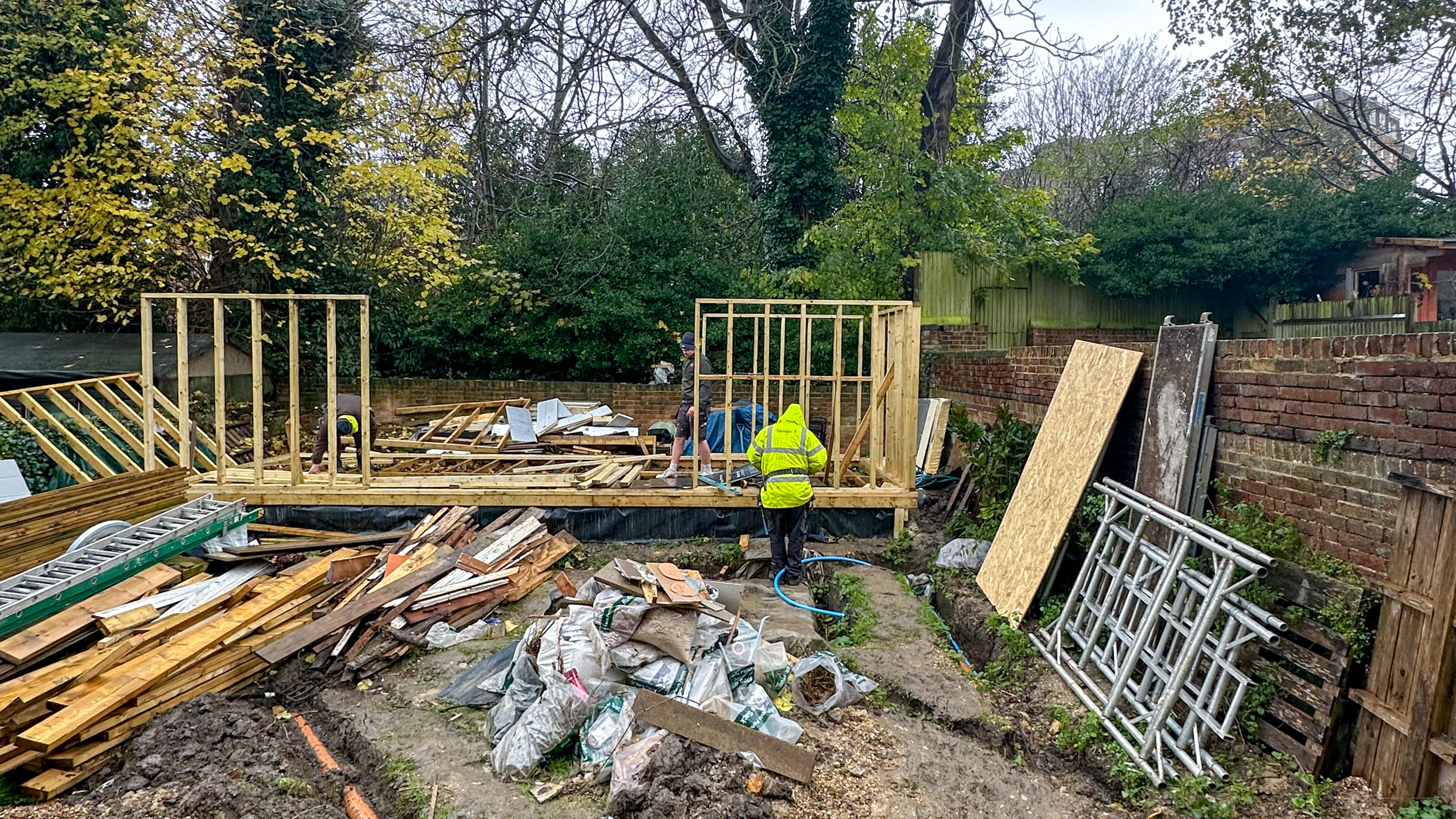 Wooden structure of summerhouse being put up in garden