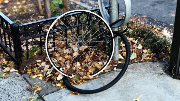 The lone wheel of a stolen bike is still locked to a post, while the tyre lies next to it