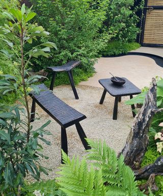 black bench and table at boodles travel garden