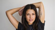 Woman with tattoo arms over head portrait - stock photo