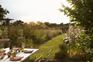 Garden by the sea in summer with a dining table