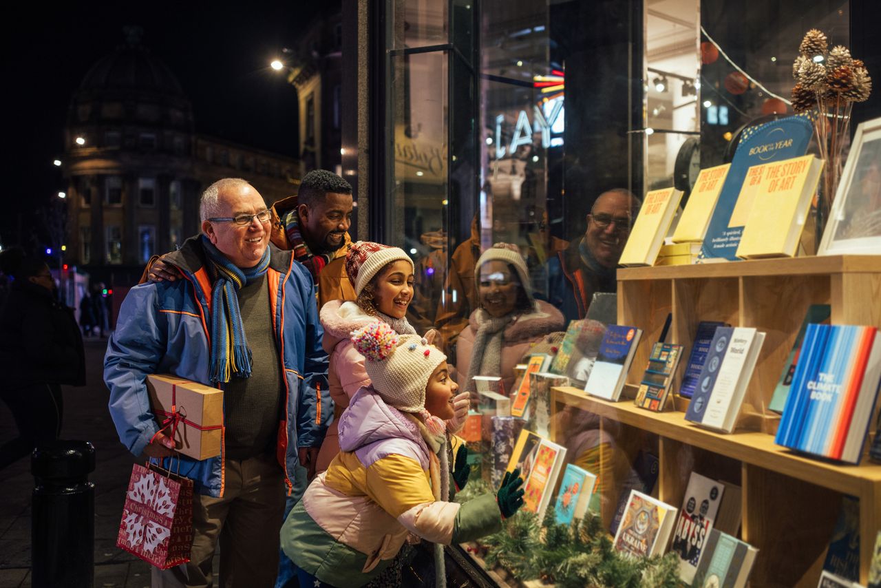 A family looks in the windows of a store during the holiday shopping season.