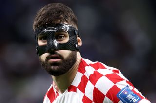 Josko Gvardiol of Croatia, wearing a protective mask, looks on during the 2022 World Cup round of 16 match against Japan in Qatar.