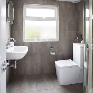 grey tiled bathroom with white window