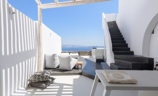 Outdoor terrace area with white walls & black stairs