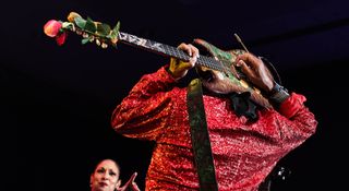 Ernie Isley plays his Fender Zeal Stratocaster onstage wearing, taking a solo – playing the guitar behind his head might have been one of the tricks he picked up from Jimi Hendrix's visits to the family home