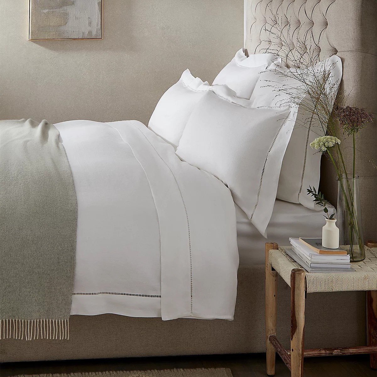 A white bed with upholstered headboard