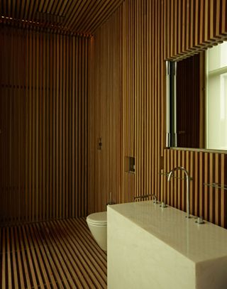 A walk-in shower with wooden panelling on the walls
