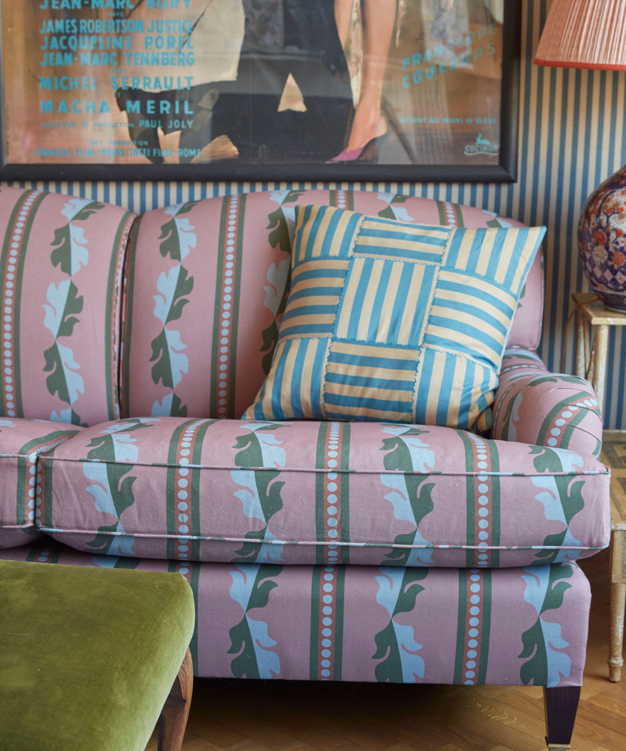 a striped living room with a pink upholstered patterned sofa