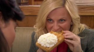 Amy Poehler as Leslie Knope eating a waffle on Parks and Recreation