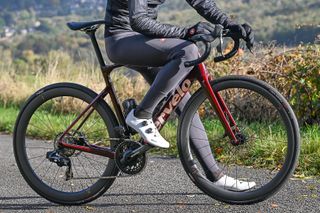 Red Cervelo Caledonia-5 bike with a rider dressed in a black jacket and grey bib tights