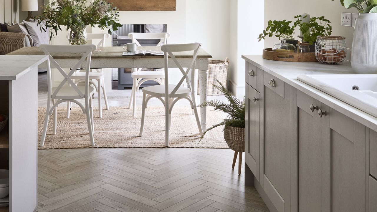 Kitchen with light grey cabinets and farmhouse table in middle.