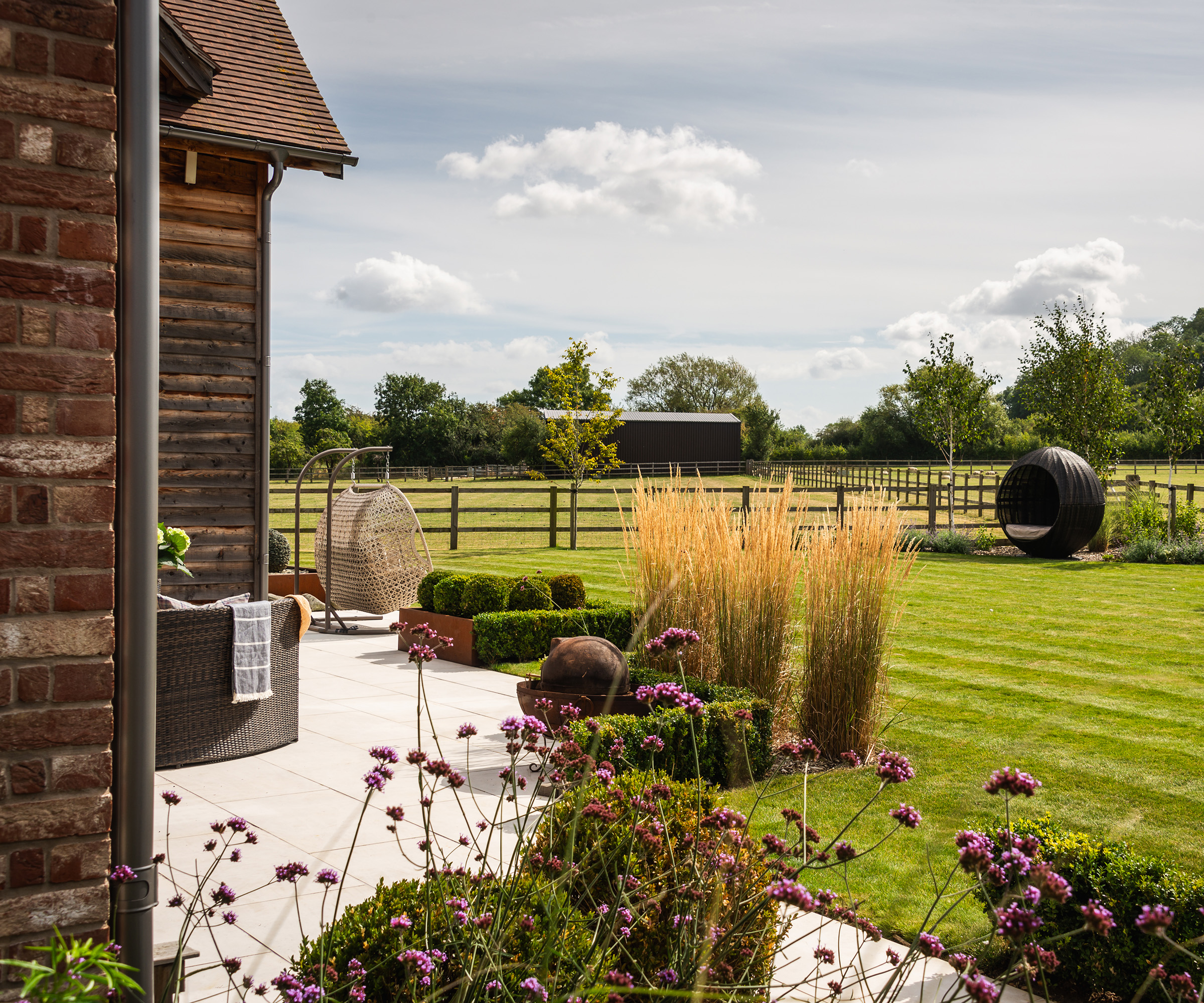 A landscaped garden area surrounding a newly built timber frame home