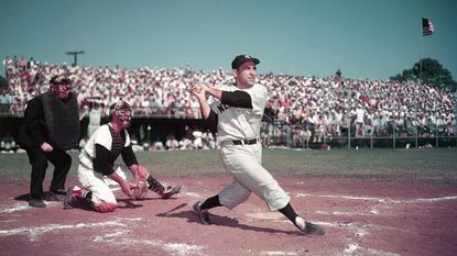 Yogi Berra, catcher for the New York Yankees, takes a swing in 1955.