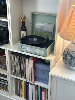 A close up of a bookshelf with a nook for vinyl storage