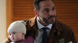 High Potential character Detective Adam Karadec holding a baby