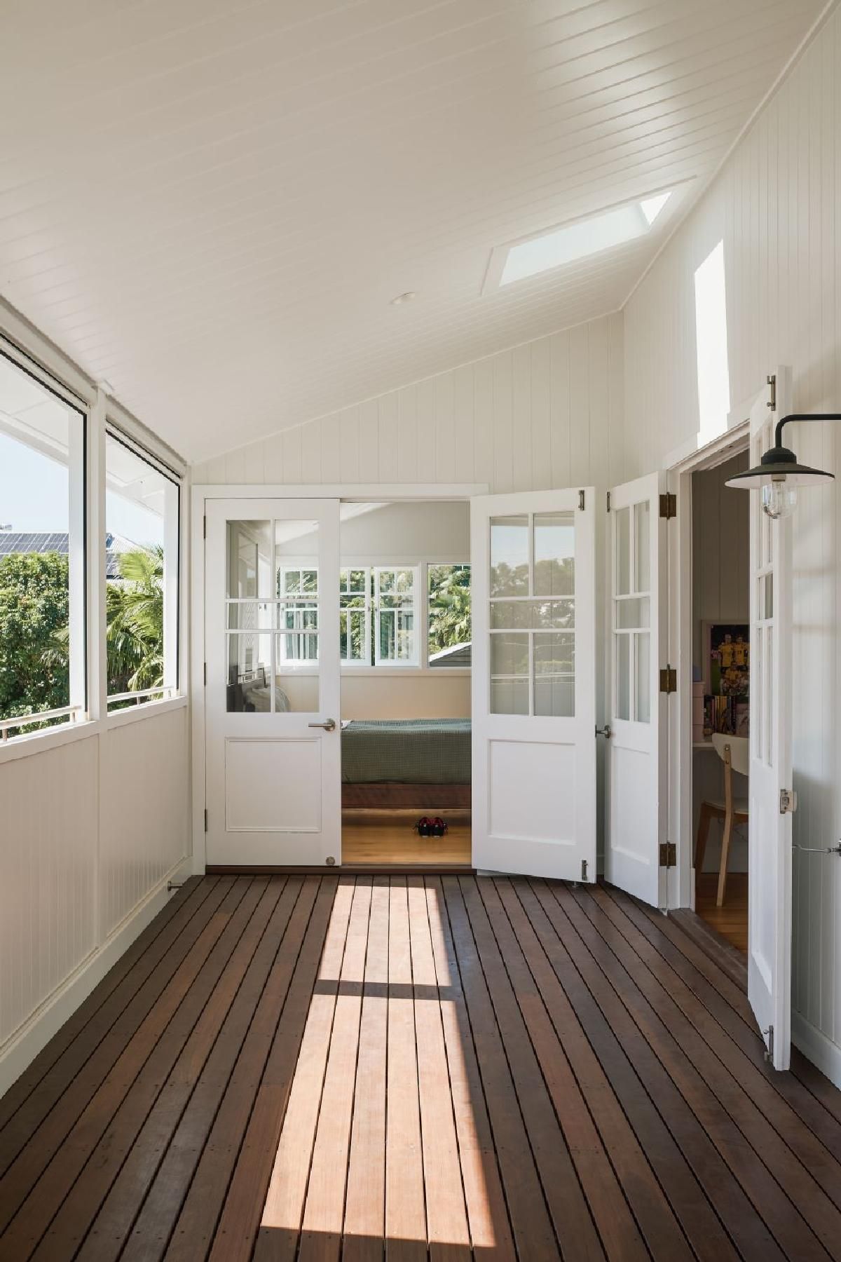 covered deck with Aussie hardwood, panelled white sloped ceiling, and french doors leading to a bedroom