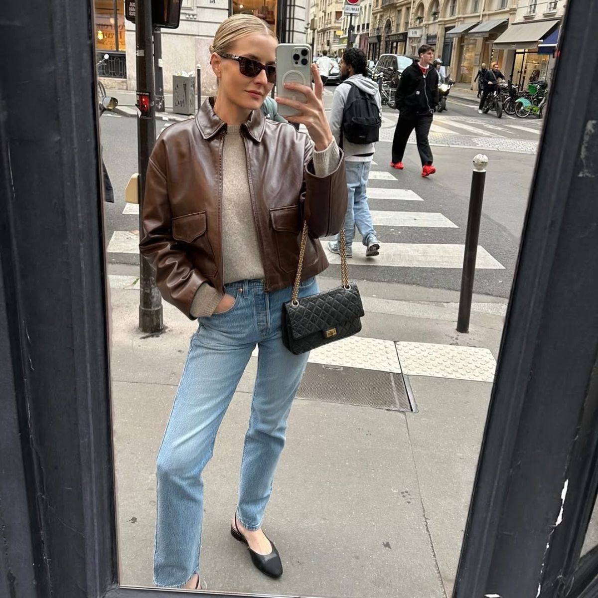 Kristen Nichols in a leather jacket, jeans, and ballet flats. 