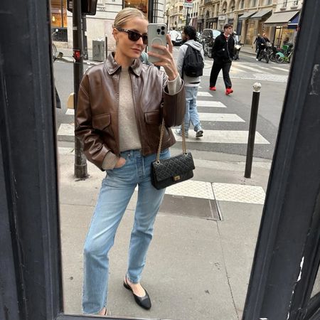 Kristen Nichols in a leather jacket, jeans, and ballet flats.