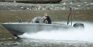 A Daniel Craig stunt double on a speedboat on the river Thames