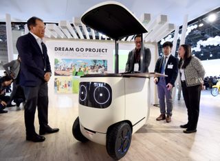 Journalists try Honda's "RoboCas Concept", electric mobility during the Tokyo Motor Show in Tokyo on October 25, 2017.RoboCas Concept is an electric cart with autonomous drive function./ AFP