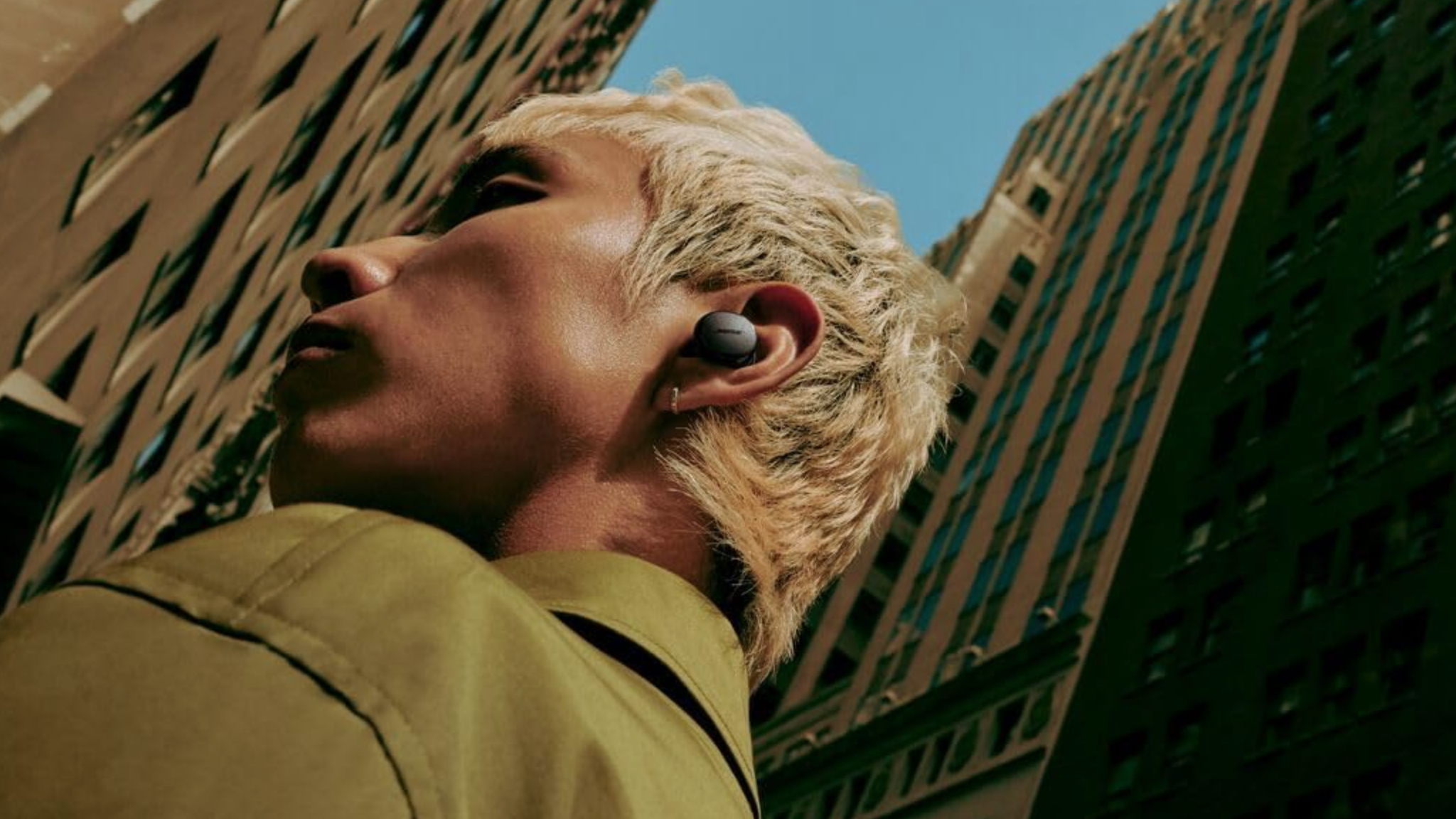 A person wearing an earbud in a city