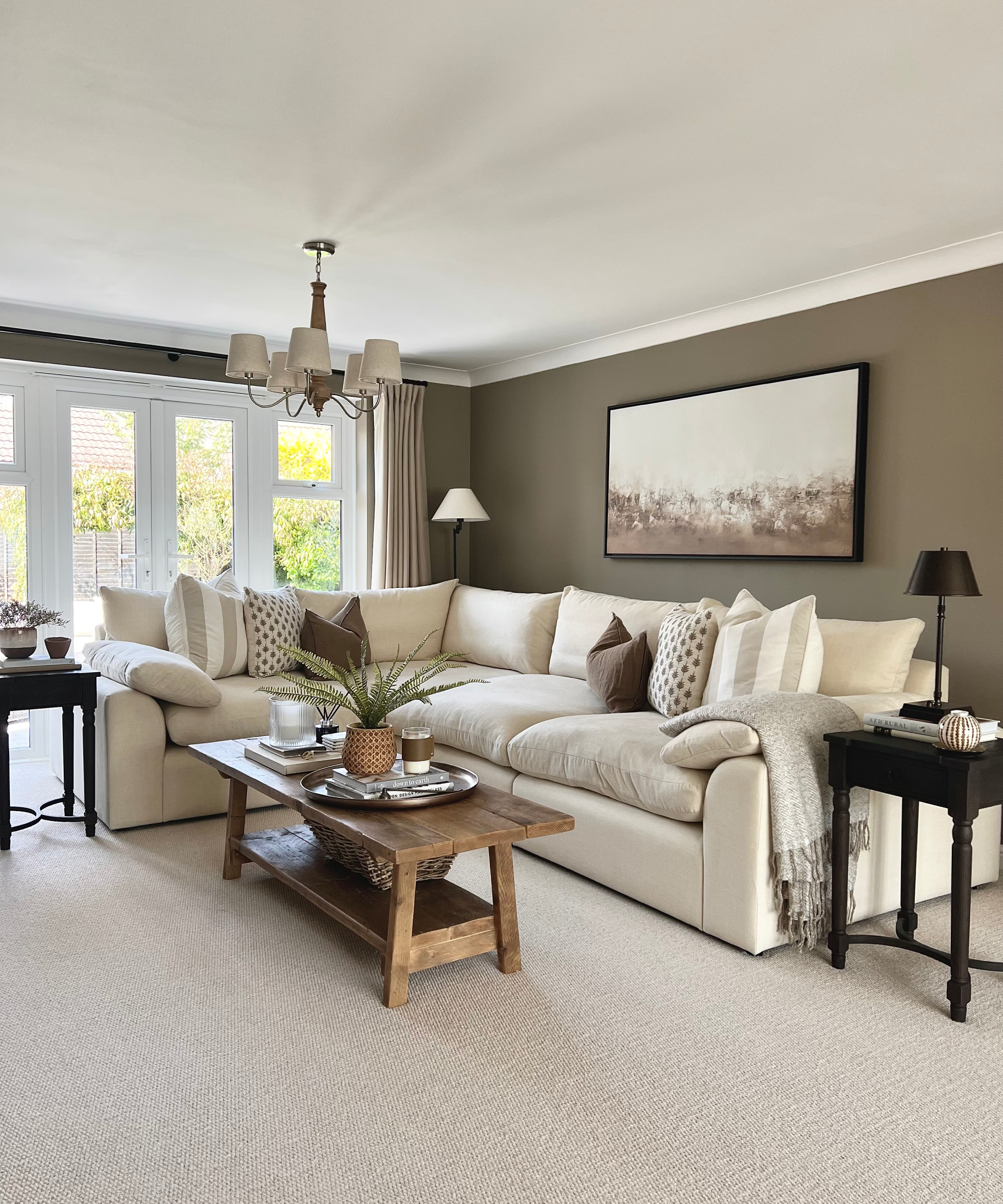 living room with cream carpet, sofas, wooden coffee table and walls painted in dark sage