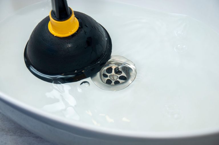 Unclogging a sink with a plunger