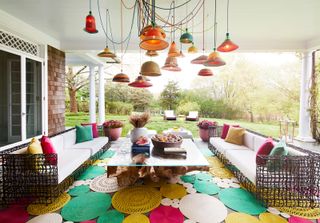 an outdoor living room with a cluster of pendant lights