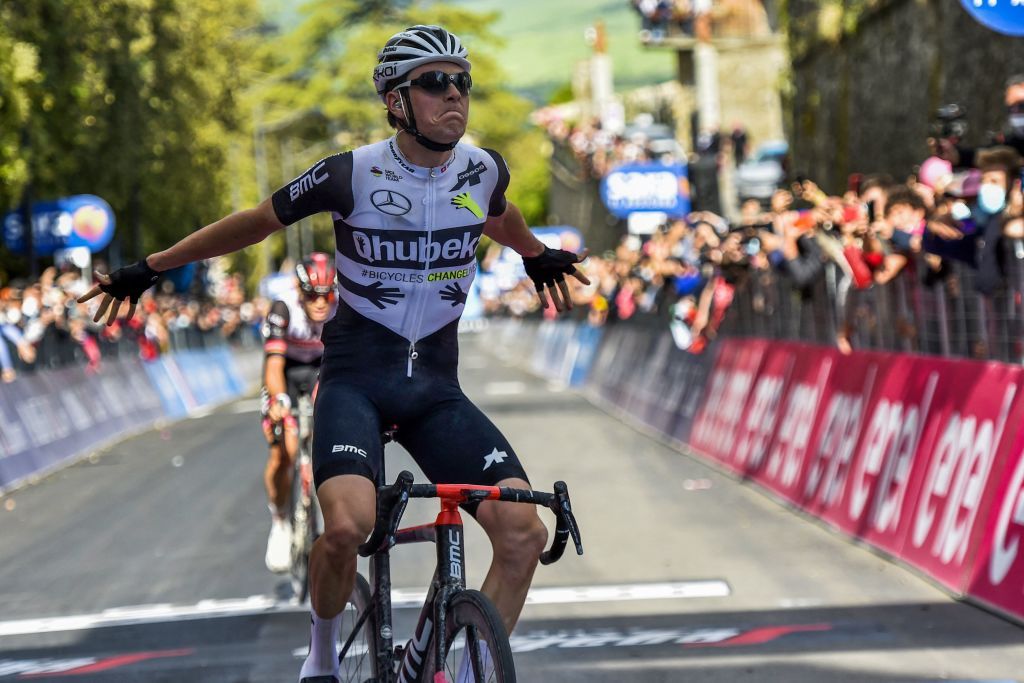 Team Qhubeka Assos rider Switzerlands Mauro Schmid celebrates as he crosses the finish line to win the eleventh stage of the Giro dItalia 2021 cycling race 162 km between Perugia and Montalcino on May 19 2021 Photo by Luca BETTINI AFP Photo by LUCA BETTINIAFP via Getty Images